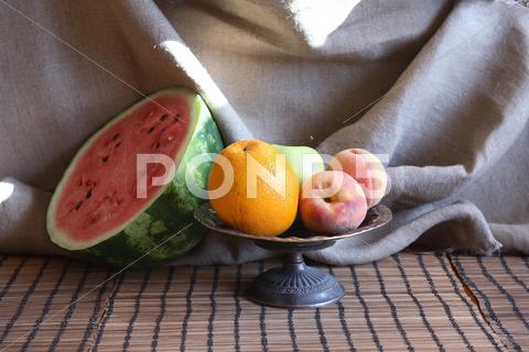 Still life with various fruits in metal bowl near sliced watermelon Fruit, Berry, Watermelon, Food, Summer, Plant, Healthy Eating, Dessert, Background, Macro, Closeup, Red, Slice, Cut, Portion, Plate, Table, Dishware, Morning, Breakfast, Bowl, Still Life, Bowl, Peach, Apple, Orange, Canvas, Decoration, Interior, Vintage, Retro