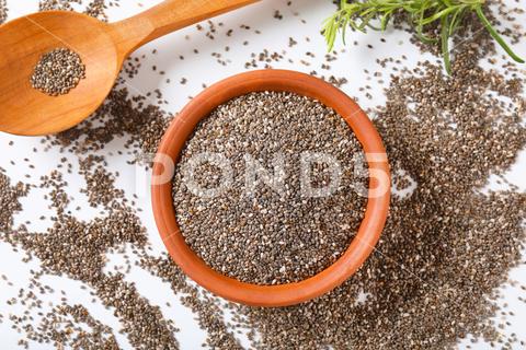Bowl of healthy chia seeds and wooden spoon on white background chia, seeds, healthy, wholesome, nutritious, antioxidant, organic, raw, pile, heap, ingredient, superfood, food, studio shot, bowl, full, above, top view, overhead