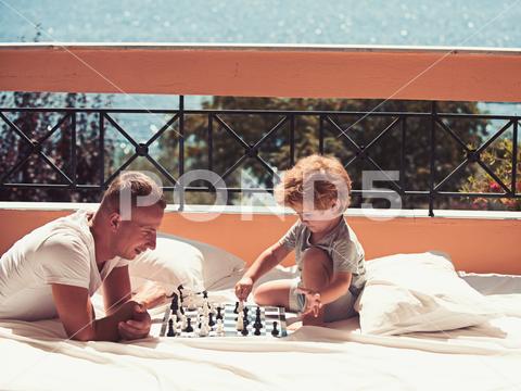 Love and trust as family values. Family travel with kid on fathers day. Summer vacation of happy family. Child play chess with father. father with son on balcony play chess. family, chess, father, son, love, vacation, happy, balcony, travel, sea, beach, play, education, game, checkers, terrace, hotel, trust, values, adorable, boy, holiday, family life, young, family vacation, idyllic, cute, happiness, wanderlust, ecology, nature, family summer, traveling, lifestyle, bermudas, little, mediterranean, youth, family travel, trip, kid, small, childhood, family holiday, Bahamas, family relations