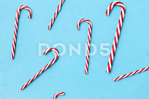 Christmas and winter holidays concept - candy cane decorations on blue background candy, candy cane, christmas, decoration, holiday, decorative, x-mas, xmas, festive, decor, beautiful, nobody, traditional, object, still life, concept, closeup, blue, background, many, white, top view, flat lay, layout