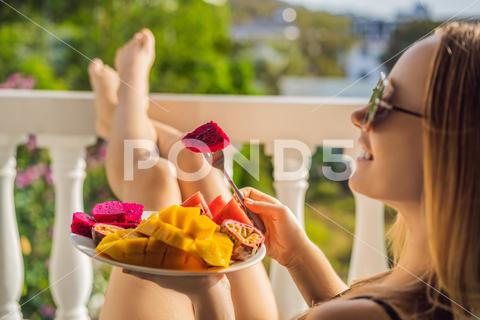 Young woman resting on a balcony with a plate of fruit. life-work balance, relaxation healthy quality living lifestyle in summer holiday vacation of freelancer woman take it easy resting in resort hotel balcony having peace of mind. woman, vacation, resort, balcony, fruit, lifestyle, hotel, holiday, healthy, work, quality, peace, mind, living, life, easy, take, street, breakfast, luxury, balance, positive, relaxation, resting, rest, travel, recreation, spa, girl, sexy, meditate, care, beautiful, beauty, pleasure, tropics, skin, hat, sun, human, home, journey, smile, gorgeous, adorable, tourism, wellness, time