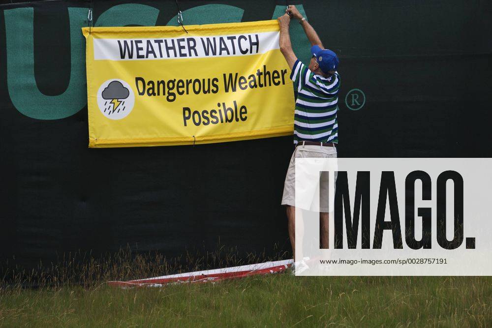En funktionär sätter upp en skylt som varnar för ett oväder som drar in över golfbanan Erin Hills inför golfturneringen US Open den 14 juni 2017 i Hartford.
