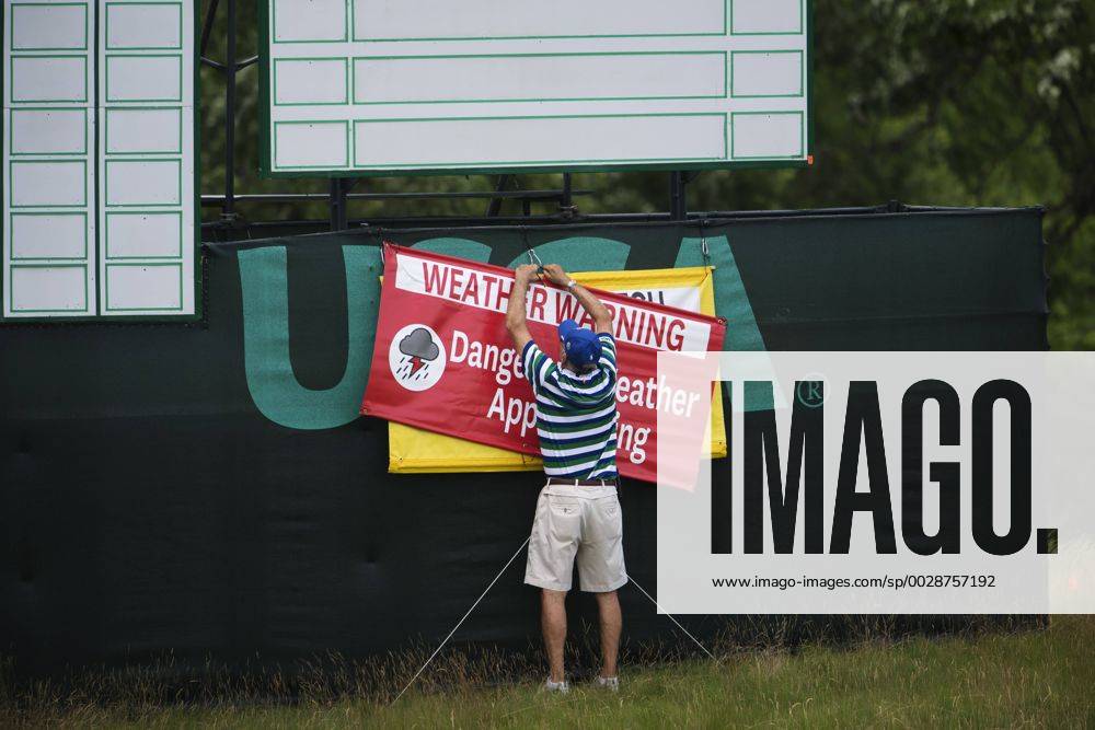 En funktionär sätter upp en skylt som varnar för ett oväder som drar in över golfbanan Erin Hills inför golfturneringen US Open den 14 juni 2017 i Hartford.