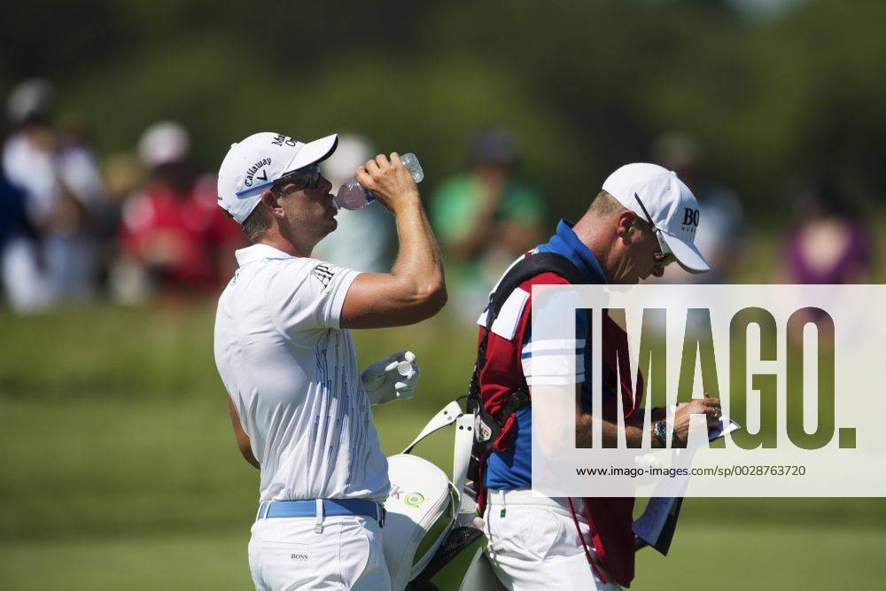 Sveriges Henrik Stenson dricker vatten bakom sin caddie Gareth Lord under första omgangen i golfturneringen US Open den 15 juni 2017 i Hartford.