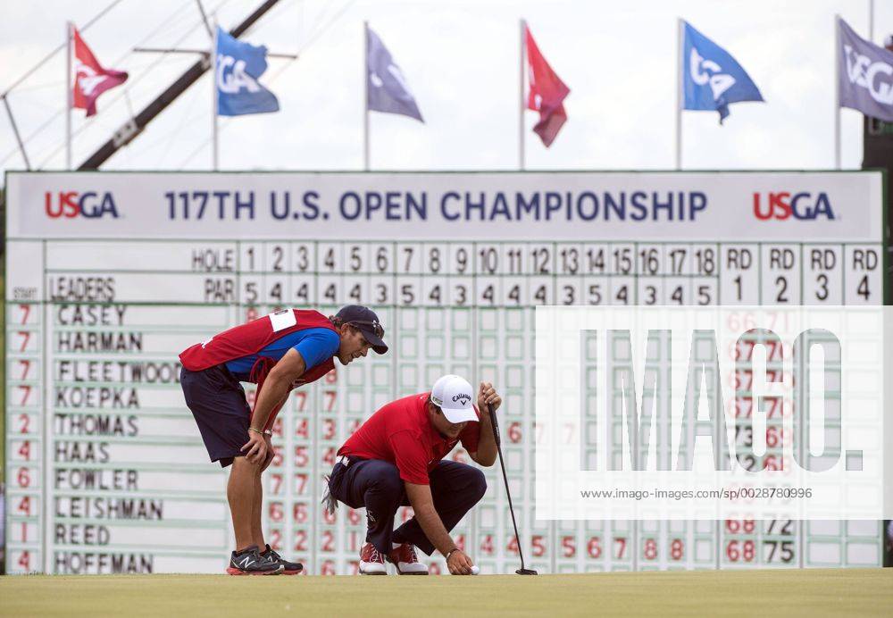 Patrick Reed and his caddie Kessler Karain line up a putt on the 18th green during round 3 of the 117th U.S. Open golf tournament at Erin Hill golf course on June 17, 2017 in Erin, Wisconsin. WIS20170617304 KEVINxDIETSCH