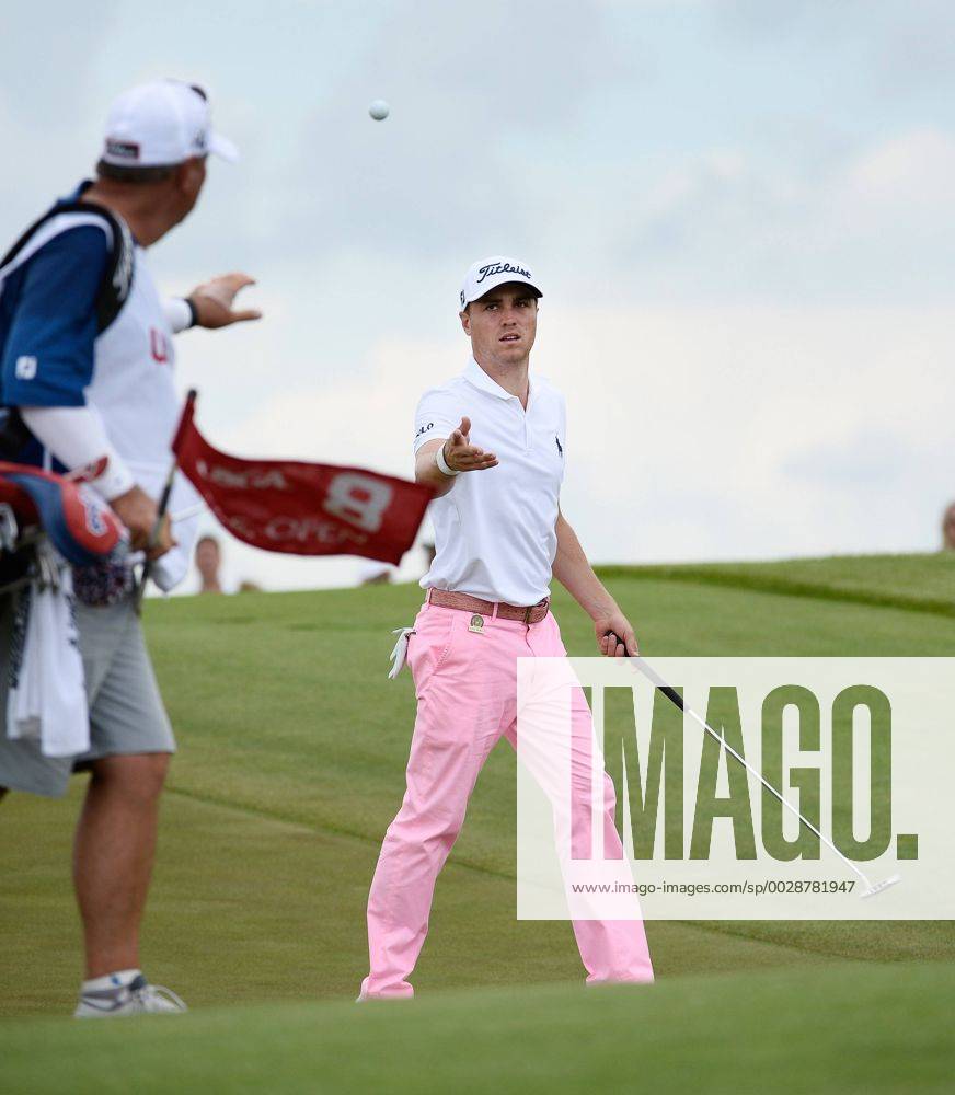 Justin Thomas tosses his ball to his caddie after making a birdie putt on the 8th hole during round 3 of the 117th U.S. Open golf tournament at Erin Hill golf course on June 17, 2017 in Erin, Wisconsin. WIS20170617101 BRIANxKERSEY