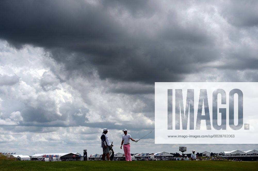 Justin Thomas (R) talks with his caddie as he waits for the group ahead on the 10th fairway during round 3 of the 117th U.S. Open golf tournament at Erin Hill golf course on June 17, 2017 in Erin, Wisconsin. WIS20170617110 BRIANxKERSEY