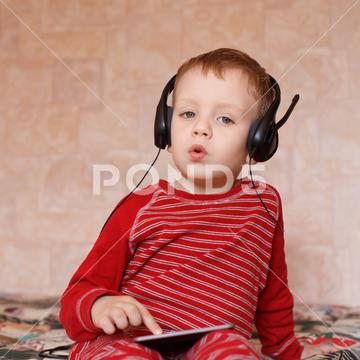 Little boy with headphones listening to music and singing boy, headphones, listen, listener, headset, cheerful, child, childhood, children, audio, baby, cute, domestic, earphones, enjoy, entertainment, equipment, expression, face, fun, guy, handsome, happiness, happy, head, headphone, home, joy, joyful, kid, leisure, lifestyle, listening, male, mp3, music, natural, one, pajamas, people, person, preteen, radio, sing, song, sound, tablet, technology, white, young