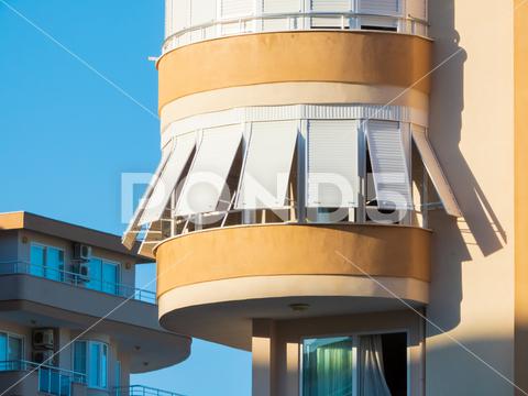 Balcony of a multi-storey residential building, protected from the rays of the hot summer sun apartment, architecture, balcony, blue, building, city, cityscape, construction, design, development, facade, home, house, modern, morning, outdoor, protection, residence, residential, sky, structure, sunlight, town, urban, white, window