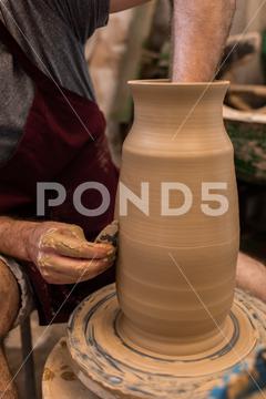 Crop unrecognizable sculptor with equipment giving shape while sculpting with brown clay on throwing wheel man, shape, clay, sculpt, equipment, process, motion, jug, ceramic, skill, male, sculptor, workshop, art, artist, handicraft, earthenware, ceramist, craft, create, dirty, form, hobby, handmade, maker, master, molding, occupation, pottery, utensil, wet, wheel, professional, work, artisan, throw, small business, talent, workplace, crop, unrecognizable, faceless, anonymous, horizontal, body part, blur, indoors