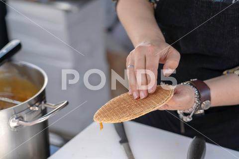 A closeup shot of a person at a local market making traditional dutch stroopwafel waffles background,bakery,chocolate,close,closeup,cook,dessert,dough,dutch,eat,farmer,food,make,market,netherlands,prepare,snack,stroopwafel,sweet,traditional,waffles