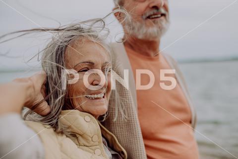 Happy senior couple relaxing and having romantic moment at the autumn sea. {{seniors,couple,man,woman,beach,shore,river,lake,sea,romantic,embrace,hug,walking,walk,active,lifestyle,retirement,pensioner,sand,happy,together,affection,elderly,senior,togetherness,love,caucasian,holding,nature,outdoors,vacation,water,coastline,human relationship,affectionate,bonding,carefree,emotion,enjoying,enjoyment,freedom,husband,outside,relaxation,romance,holding hands,embracing}}