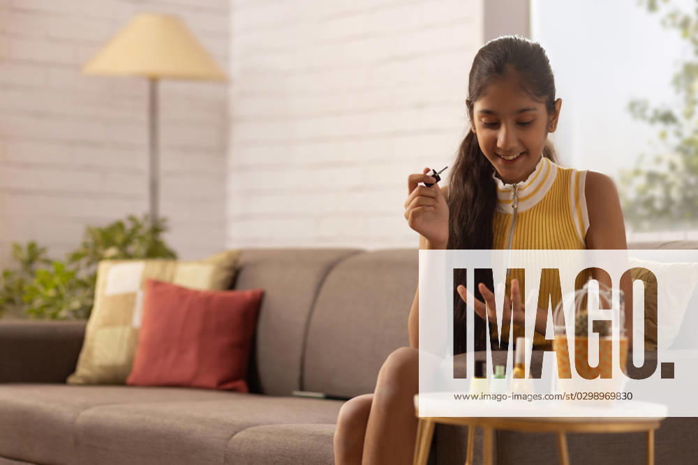 Tween girl painting her finger nails