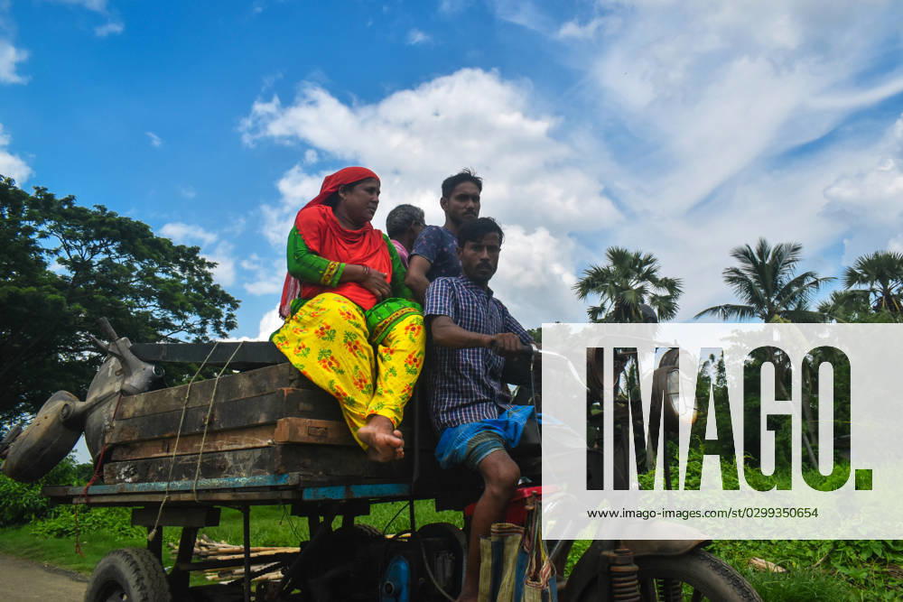 Daily Life On The Outskirts Of Kolkata, India People are traveling on a tricycle van on the outskirts of Kolkata, India on 16 July 2023. Kolkata West Bengal India