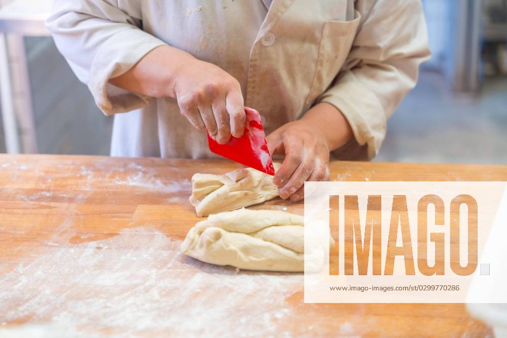 Employees one Bread machines in the Workshop a handicraft Bakery at Cutting from Dough