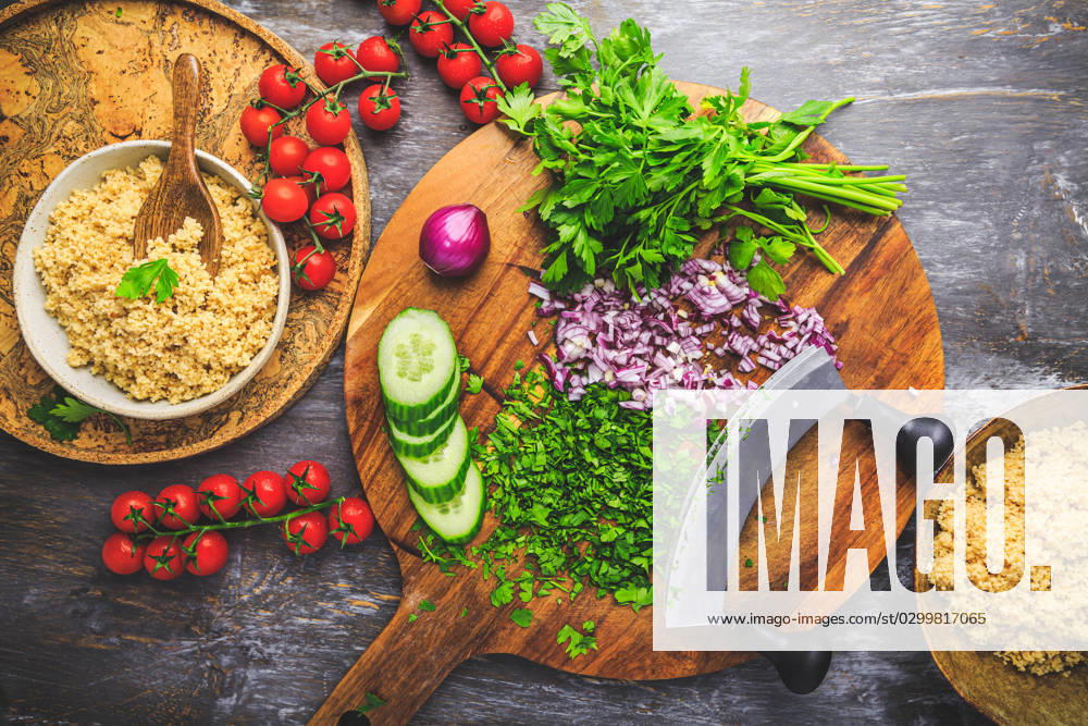 Preparing traditional oriental salad Tabouleh with couscous or bulgur Preparing traditional oriental salad Tabouleh with couscous or bulgur, ingredients on cutting board