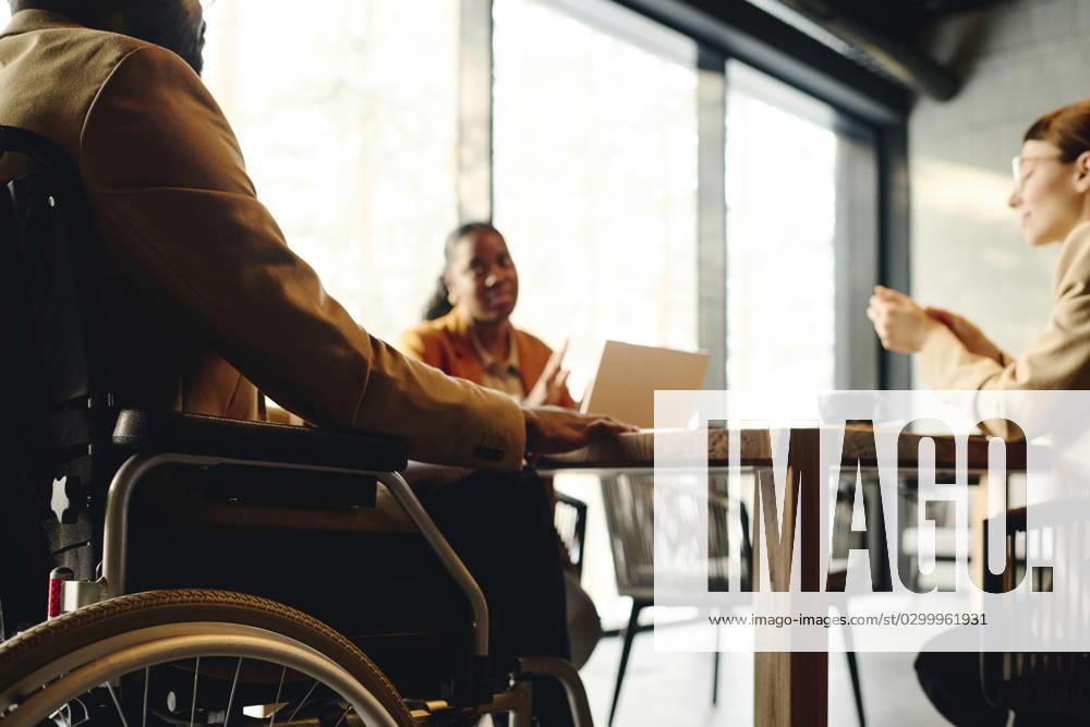 Businessman in wheelchair discussing with coworkers at conference table model released, Symbolfoto property released, DSHF00856