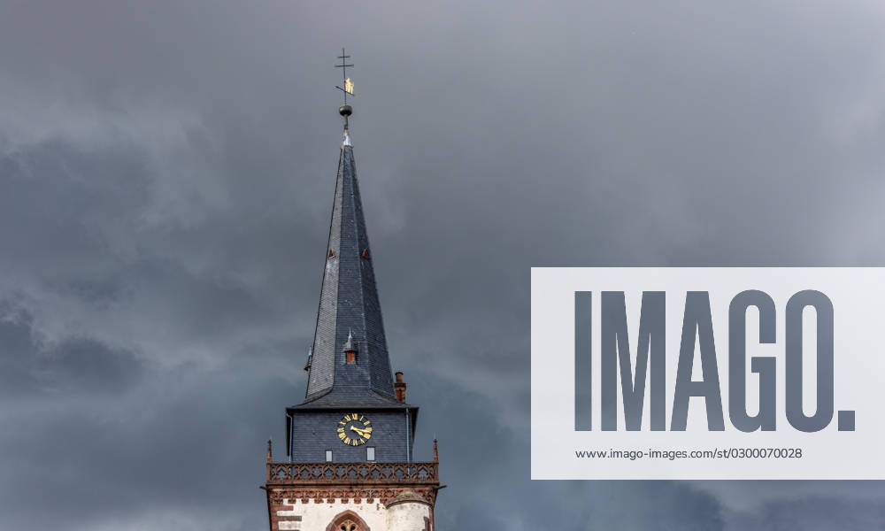 Dark clouds over the church tower Dark clouds of a thunderstorm are seen in the afternoon in the sky above the tower of the Catholic Church St Ursula , Oberursel Hesse Germany