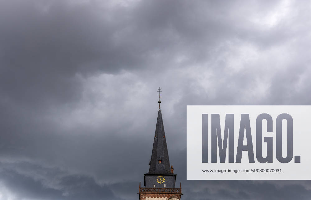 Dark clouds over the church tower Dark clouds of a thunderstorm are seen in the afternoon in the sky above the tower of the Catholic Church St Ursula , Oberursel Hesse Germany
