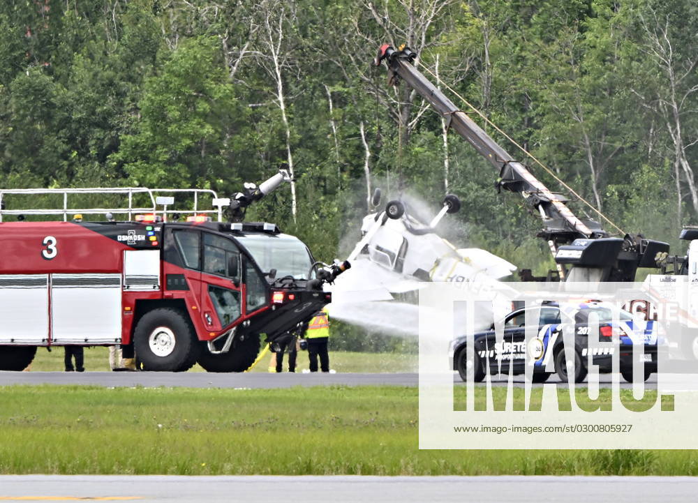 Firefighters spray down a Cessna 152 aircraft as it is towed away after it crashed on landing at the Jean-Lesage Airport in Quebec City, Tuesday, Aug. 1, 2023. One person was reported injured. QUEBEC Canada - ZUMAc35_ 20230801_zaf_c35_022