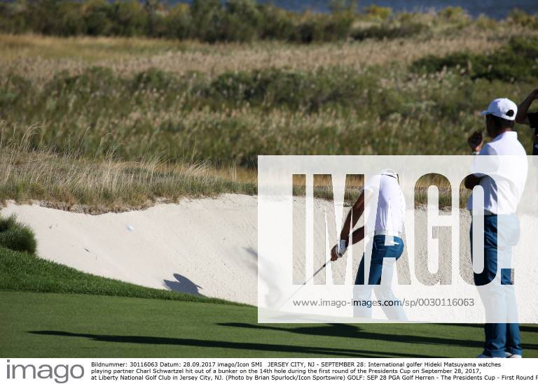 JERSEY CITY, NJ - SEPTEMBER 28: International golfer Hideki Matsuyama watches playing partner Charl Schwartzel hit out of a bunker on the 14th hole during the first round of the Presidents Cup on September 28, 2017, at Liberty National Golf Club in Jersey City, NJ. (Photo by Brian Spurlock Icon Sportswire) GOLF: SEP 28 PGA Golf Herren - The Presidents Cup - First Round Icon17092861