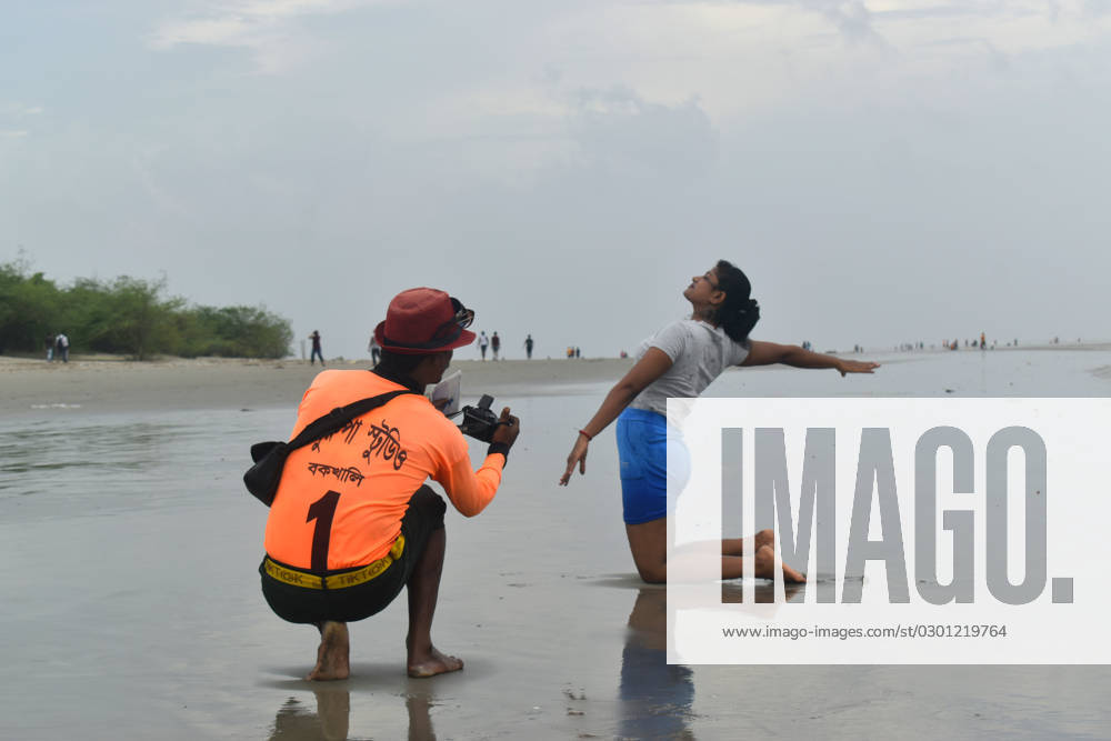 Story Of A Sea Beach Photographer At Bakkhali Mrityunjay Majhi taking a photo of a tourist in Bakkhali sea beach, West Bengal India on 05 August 2023. Mrityunjay Majhi, 38, is a sea beach photographer at Bakkhali sea beach. He takes photos of tourists with his camera and after that taking a print out and delivered them to the hotels. In sea beaches people want to making memories and sea beach photographers help are making it, but nowadays people don t take photos, due to mobiles and all orther gadgets said, Mrityunjay Majhi, also said Previously I earned sufficient but now days its became tough, many of my friends are shifting to others profession, but i dont. I love to captured the moment and i want to go with this, hope situation would
