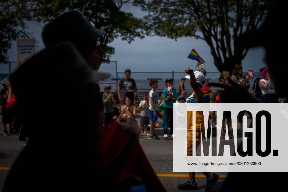 A boy waves a flag at people in the crowd during the Pride Parade at English Bay in Vancouver, B.C., Sunday, Aug. 6, 2023. VANCOUVER CANADA - ZUMAc35_ 20230806_zaf_c35_015