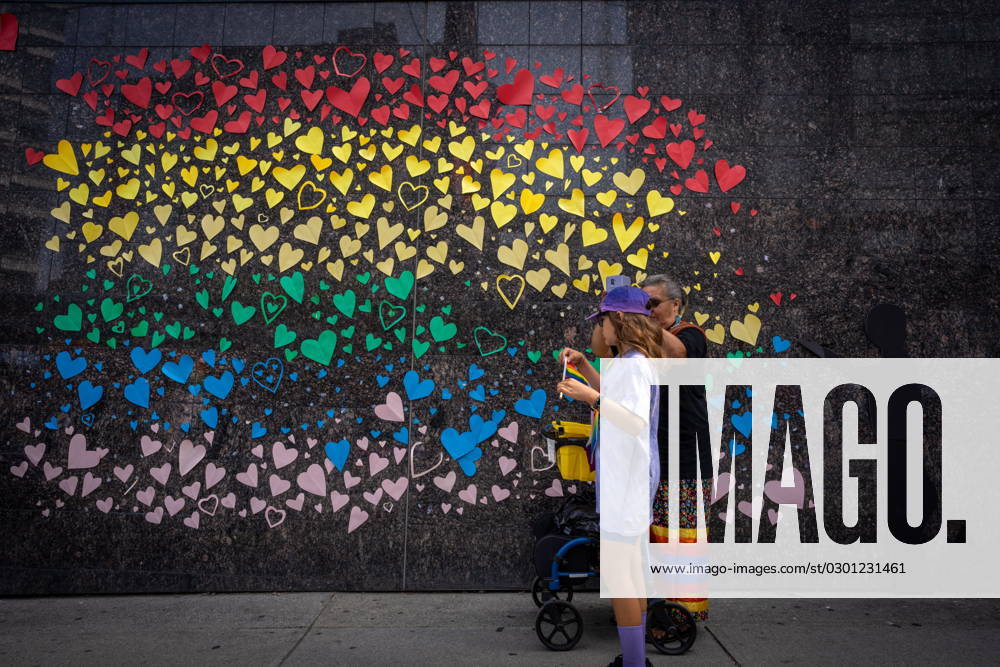 People pass a decorated wall during the Pride Parade at English Bay in Vancouver, B.C., Sunday, Aug. 6, 2023. VANCOUVER CANADA - ZUMAc35_ 20230806_zaf_c35_019