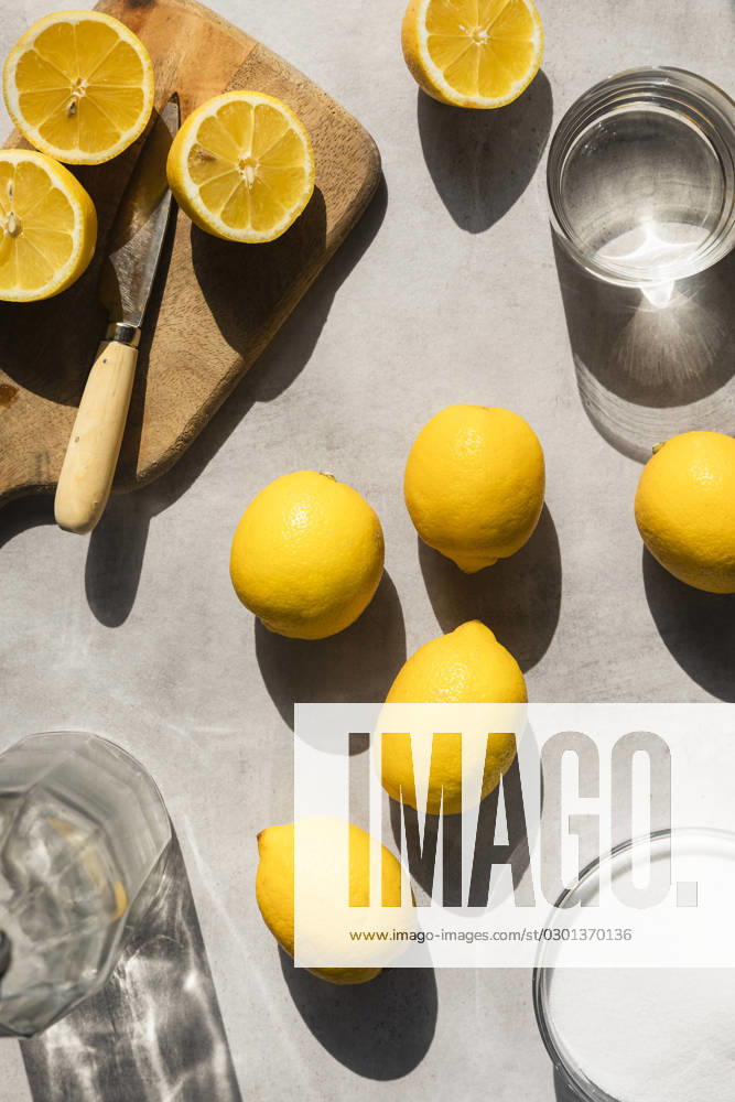 Lemons in hard light, with sugar, water and sliced lemons surrounding. Lemons in hard light, with sugar, water and sliced lemons surrounding.