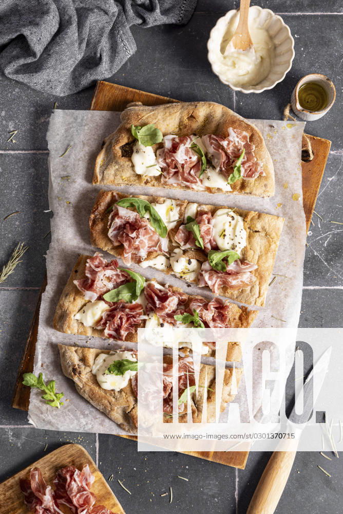 Slices pinsa with prosciutto, cheese, arugula Slices pinsa with prosciutto, cheese, arugula