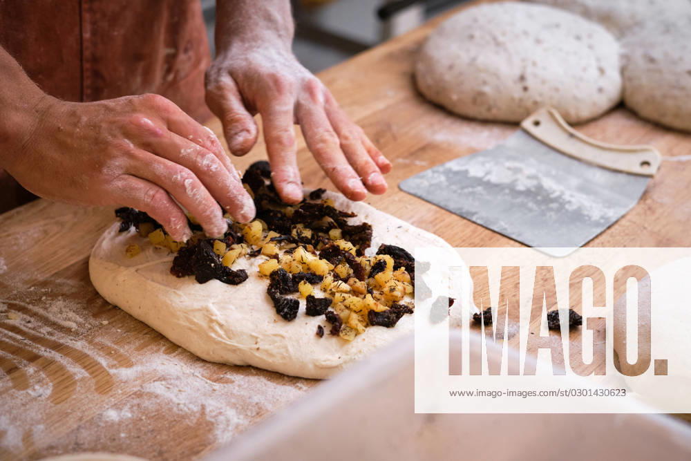 Detail of a baker s hands introducing ingredients into the bread dough. Detail of a baker s hands introducing ingredients into the bread dough. . High quality photo Model Released PhilippeDegroote_ID14492_436185_037