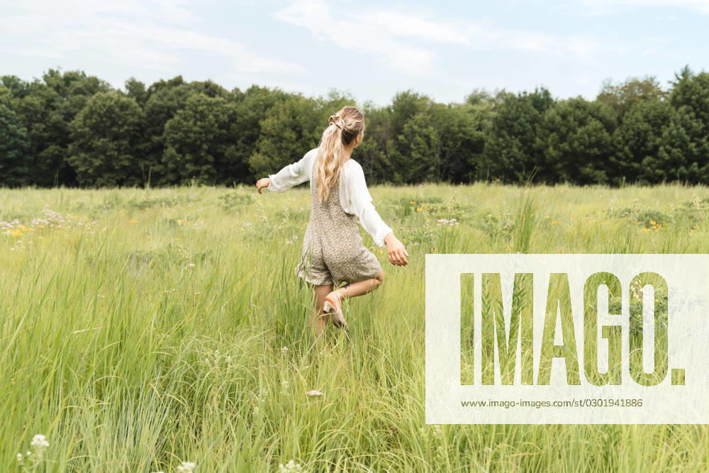 IMAGO Creative, Jahreszeit Sommer, Sommerferien A woman in a romper dancing in a field of grass Iowa City, Iowa, United States CR_VGMI230815-1231672-01 ,model released, Symbolfoto