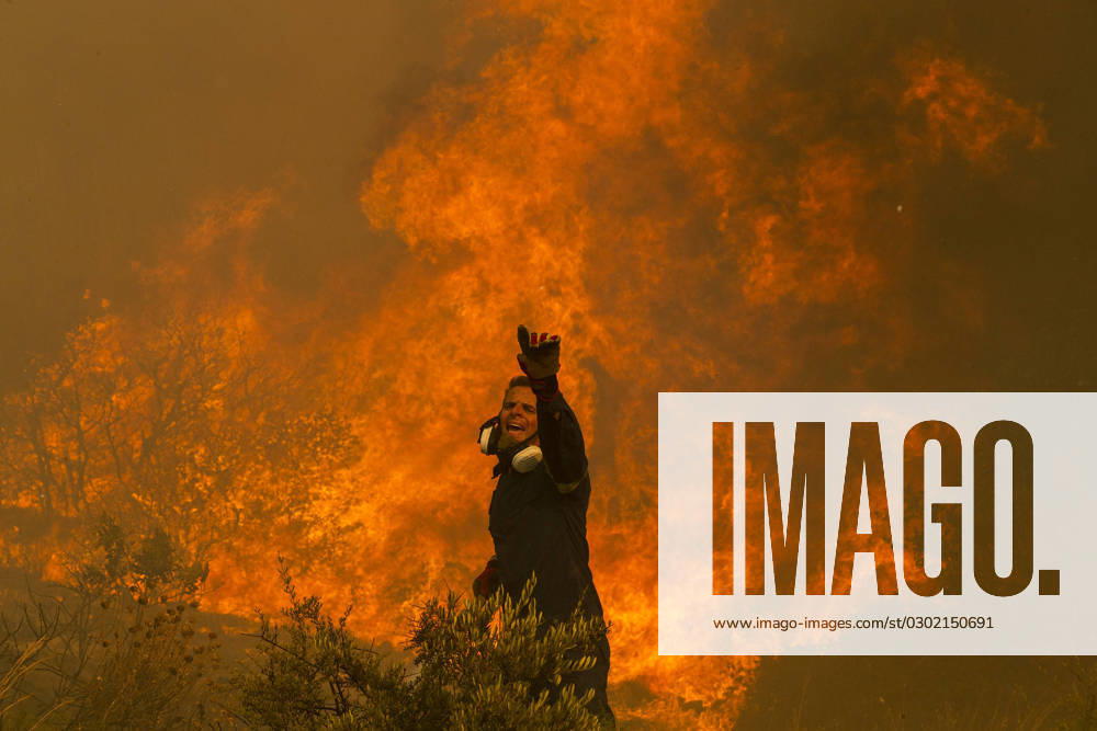 (230822) -- HASIA (GREECE), Aug. 22, 2023 -- A firefighter battles a wildfire in Hasia village, near Athens, Greece, on Aug. 22, 2023. Wildfires, erupted on Tuesday near the Greek capital, forced the evacuation of settlements and the closure of roads. ) GREECE-HASIA-WILDFIRES MariosxLolos