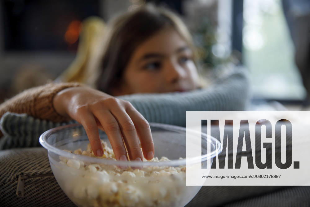 Girl having popcorn from bowl at home model released, Symbolfoto property released, IKF01108