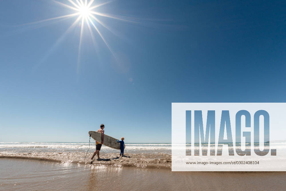 Father and son carrying surfboard on sunny day M?hia, Hawke s Bay, New Zealand CR_JUCR230809D-757468-01 ,model released, Symbolfoto