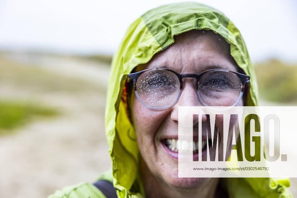 Woman with Rain jacket and Raindrops at the Glasses comes drenched from Walking tour on Sea back, Portbail, Cotentin, Some, Normandy, France, Europe