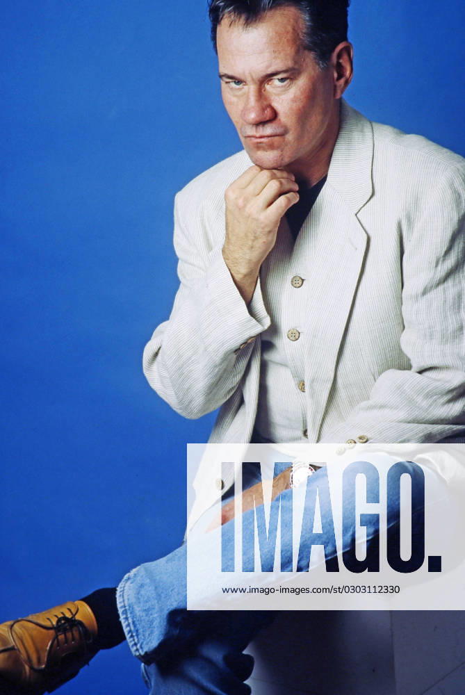 Manfred Lehmann, deutscher Schauspieler und Synchronsprecher, in Jeans und weißem Jackett mit Weste im Fotostudio, Deutschland 1996. Deutschland