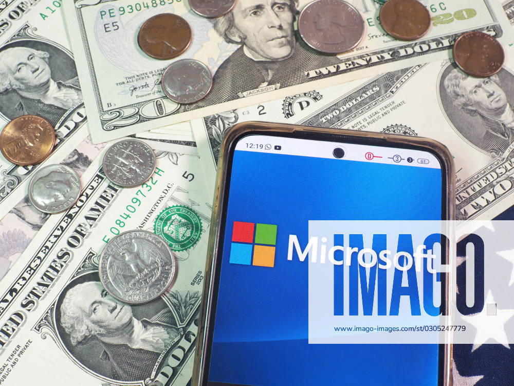 Logos displayed on smartphones in Germany - 22 Sept 2023 In this photo illustration, Microsoft Corporation logo seen displayed on a smartphone with United States Dollar Currencies on the table. Germany