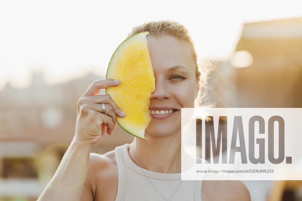 Smiling woman covering her face with yellow watermelon model released, Symbolfoto, SIF00810