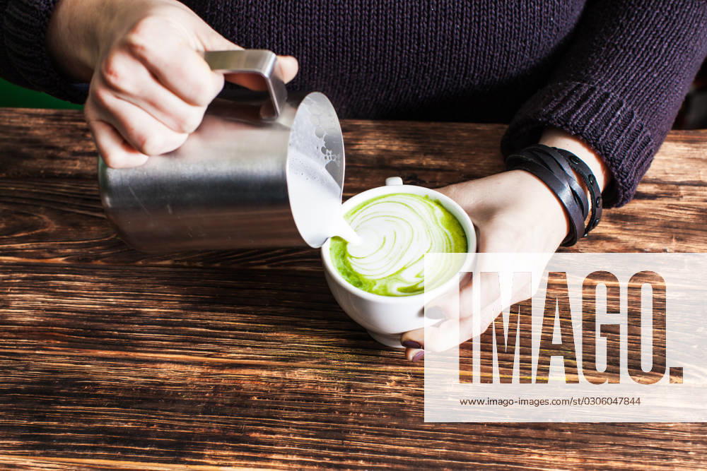 Process of pouring milk in matcha tea cup Process of pouring milk in matcha tea cup for make latte art. Close up hands ,model released, Symbolfoto