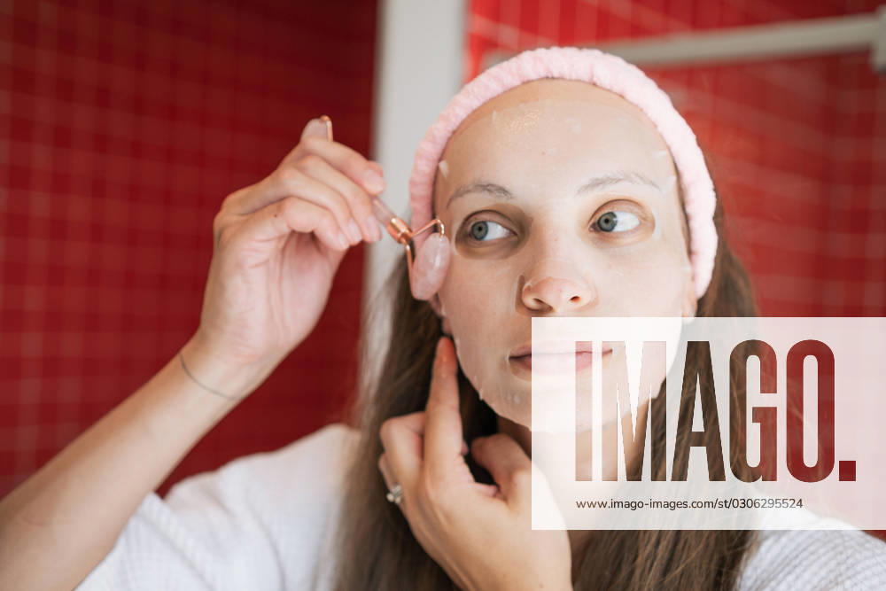 White Female Happy Doing Her Skincare Routine in The Morning Before Bed Skincare routine white female in a bright bathroom shaving legs with a razor and applying ,model released, Symbolfoto