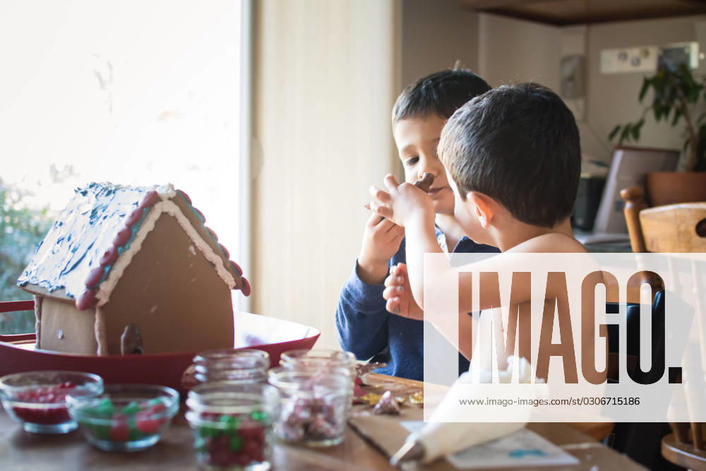 Young boys sampling candy while decorating a gingerbread house. Washington, District of Columbia, United States R_YWPB231001E-1260474-01 ,model released, Symbolfoto