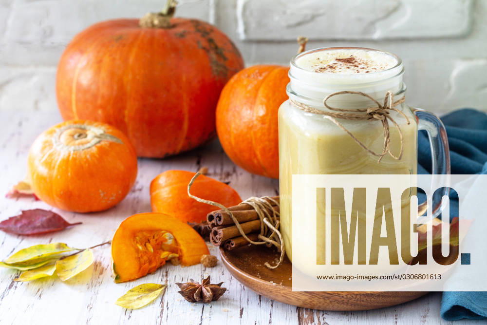Autumn drink. Pumpkin spiced latte or coffee in glass on a rustic wooden table. Autumn drink. Pumpkin spiced latte or coffee in glass on a rustic wooden table.