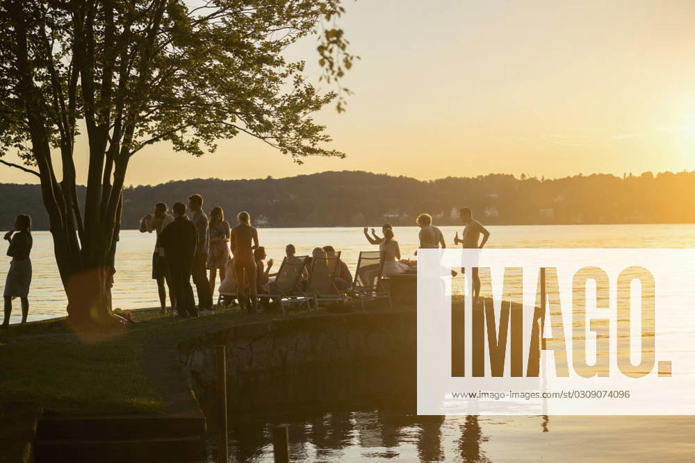 Group of young friends partying at lakeside during sunset, Bavaria, Germany Bavaria, Germany, Europe CR_RONI150802-00214-01 ,model released, Symbolfoto