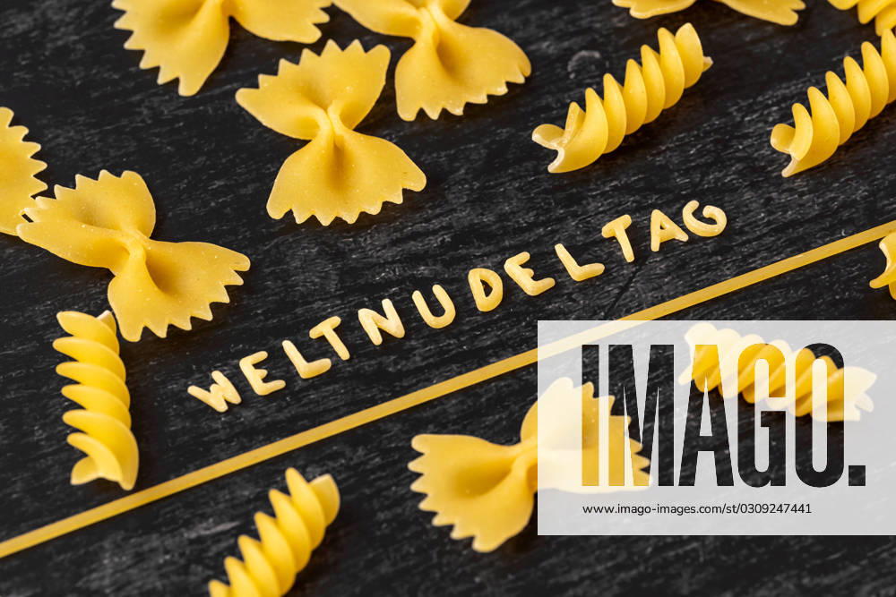 Augsburg, Bavaria, Germany - 19 October 2023: World Noodle Day word formed from letter noodles amidst various noodle varieties. Symbol image World Noodle Day on 25 October