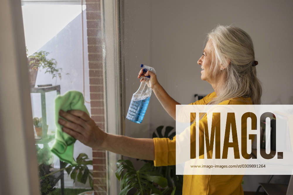 Woman cleaning glass of window at home model released, Symbolfoto property released, JCCMF10807