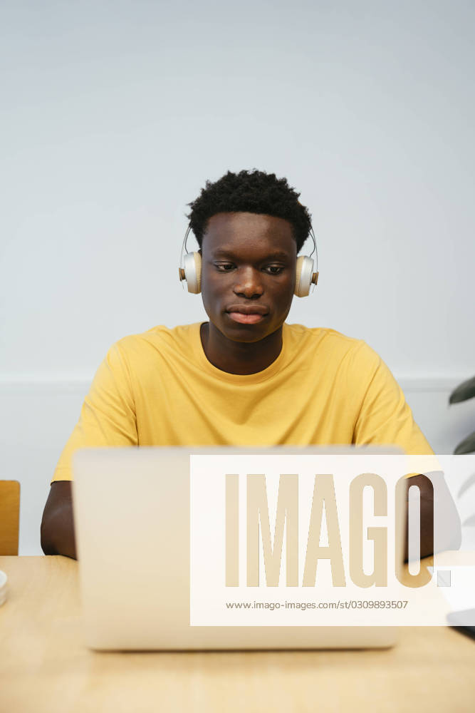 Tschechien, Hochschule streicht wegen KI und Plagiate Bachelorarbeiten Student wearing wireless headphones using laptop at desk model released, Symbolfoto property released, EBSF03862