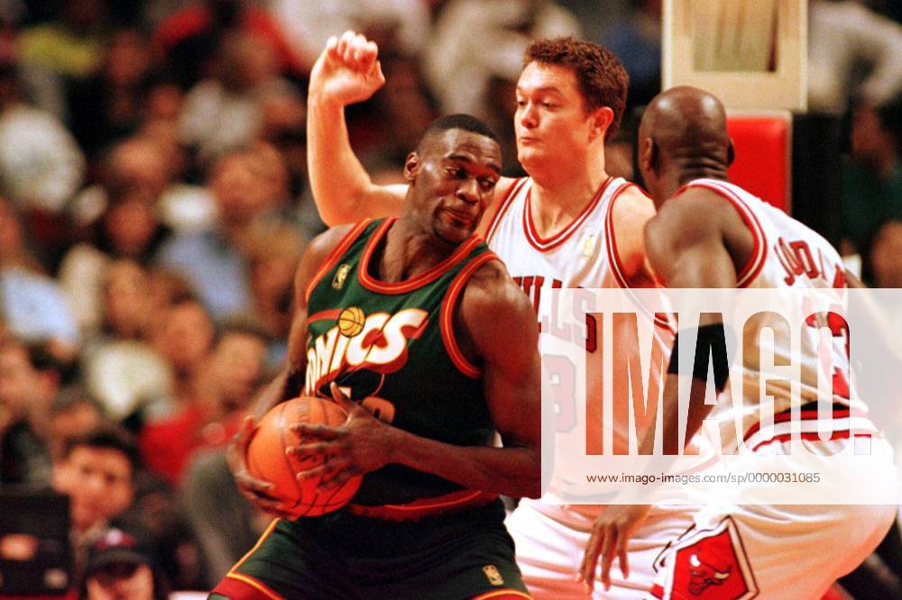 Seattle-Forward Shawn Kemp versucht sich mit Ball gegen Luc Longley und Michael Jordan (re.) durchzusetzen Basketball Herren NBA, Saison 1996 97: Chicago Bulls - Seattle Supersonics Gruppe United Center Chicago Dynamik, Kampf,
