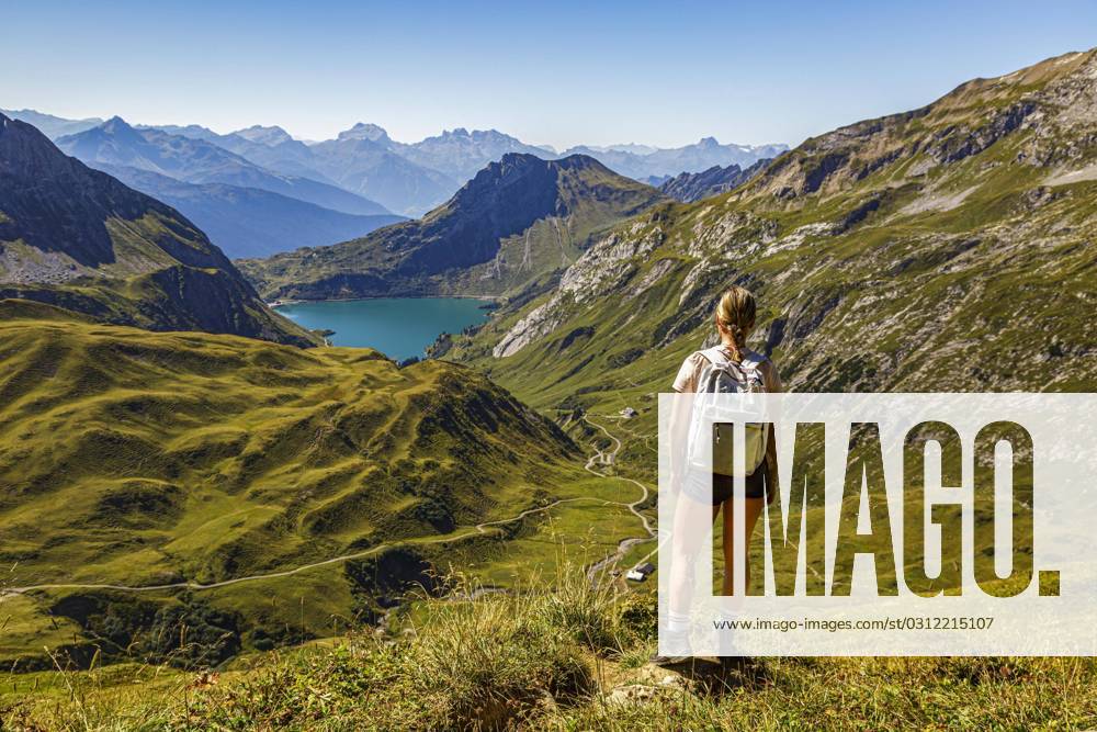 A Boy Woman is to a Hiking trail at a mountain and looks at the Spullersee in Vorarlberg Lech Austria