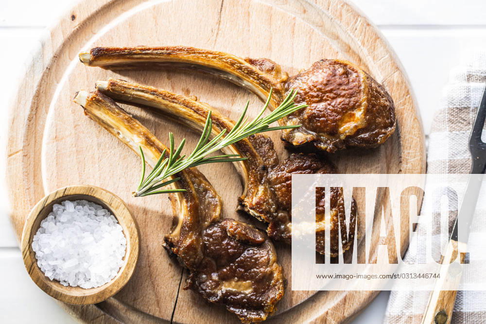 Grilled lamb chops on cutting board. Grilled lamb chops on wooden cutting board. Top view.